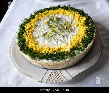 Close up of a beautiful homemade colorful salty cake `"Mimosa" on a white table in the dining room. Stock Photo